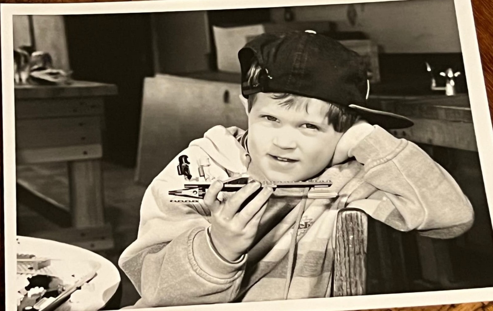 Black and white photo of a young Byars brother in a ball cap holding a harmonica