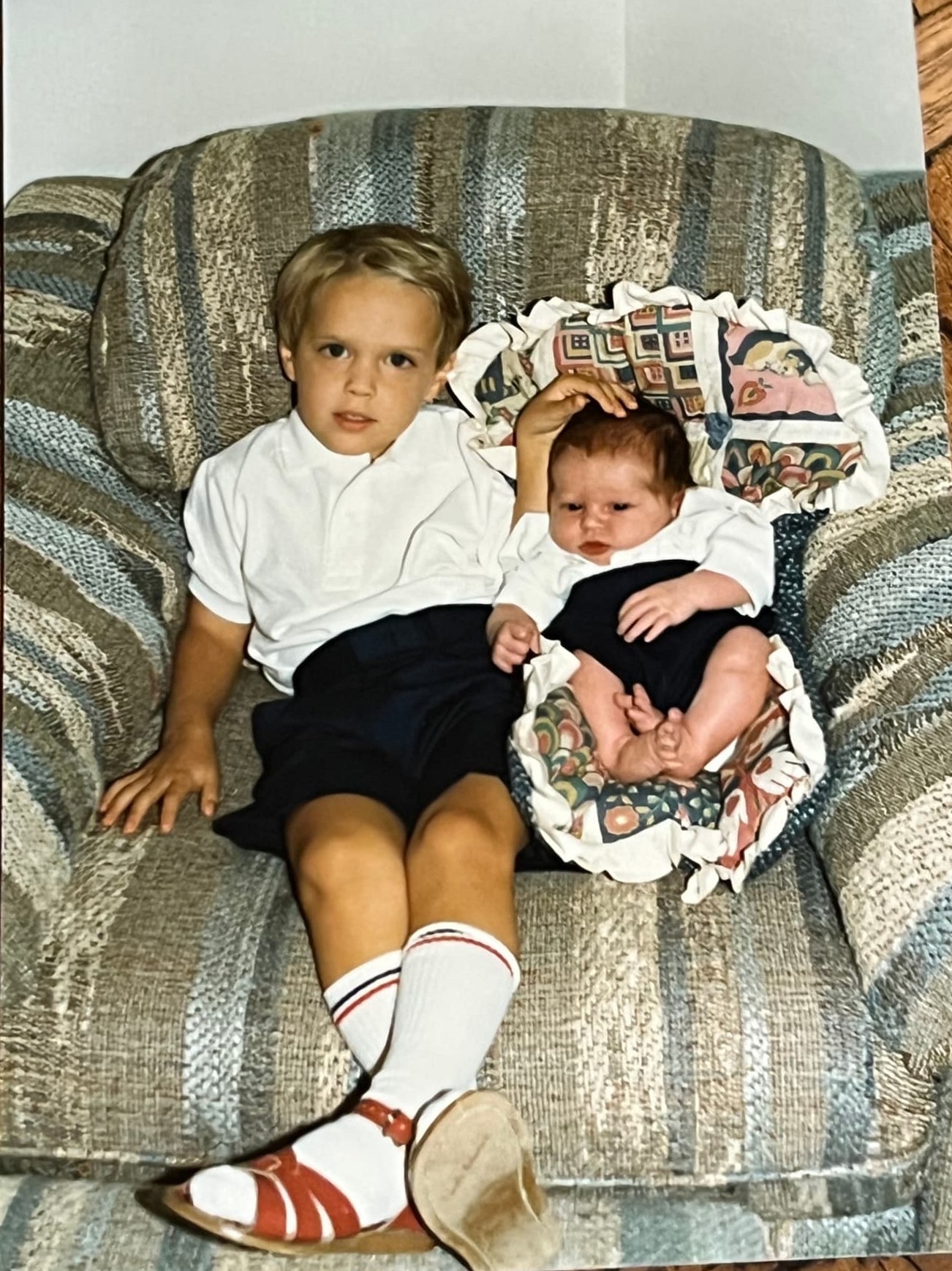 A young Byars brother on an armchair beside his newborn brother