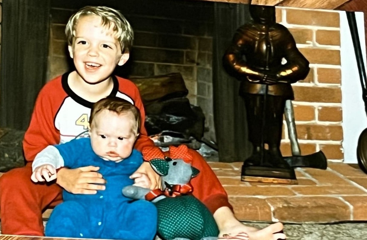 The Byars brothers in pajamas by the fireplace at Christmas