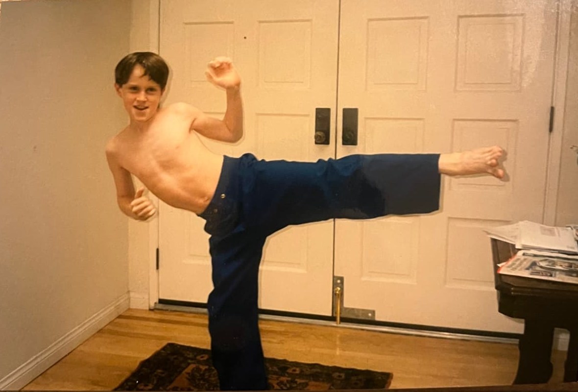 A young Byars brother throwing a high karate kick in the living room